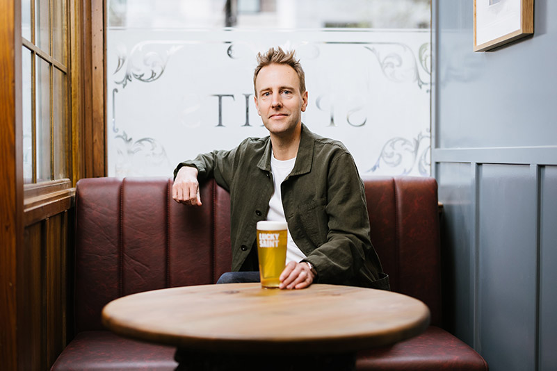Man sitting at pub table with beer